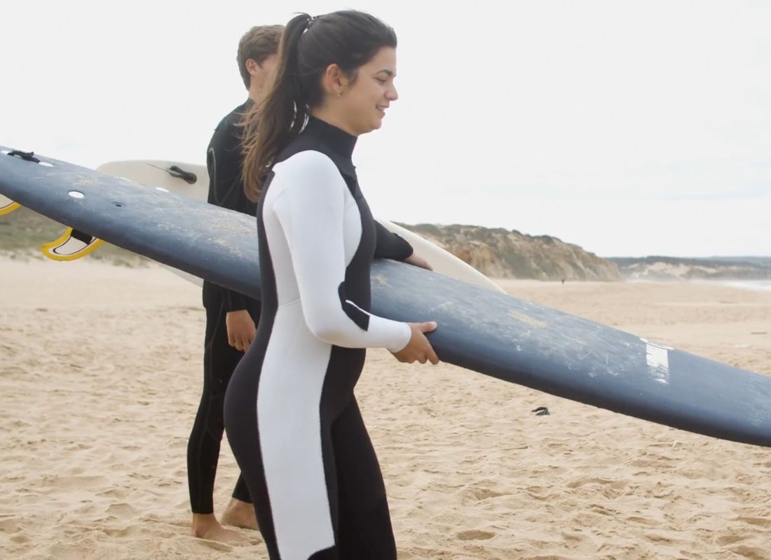 devojka u neoprenskom odelu ide na surfovanje