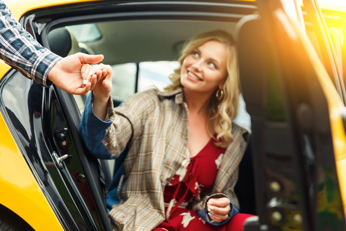 osoba daje ruku devojci da izađe iz automobila